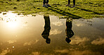 People, fitness or reflection with puddle for workout discussion, routine or sunset exercise. Silhouette, man and woman talking on grass field at lake or pond for physical activity together in nature