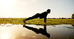 Man, fitness and nature with push ups by lake for workout, arm exercise or physical activity. Active, male person and lifting body weight with reflection by pond for outdoor training or muscle gain