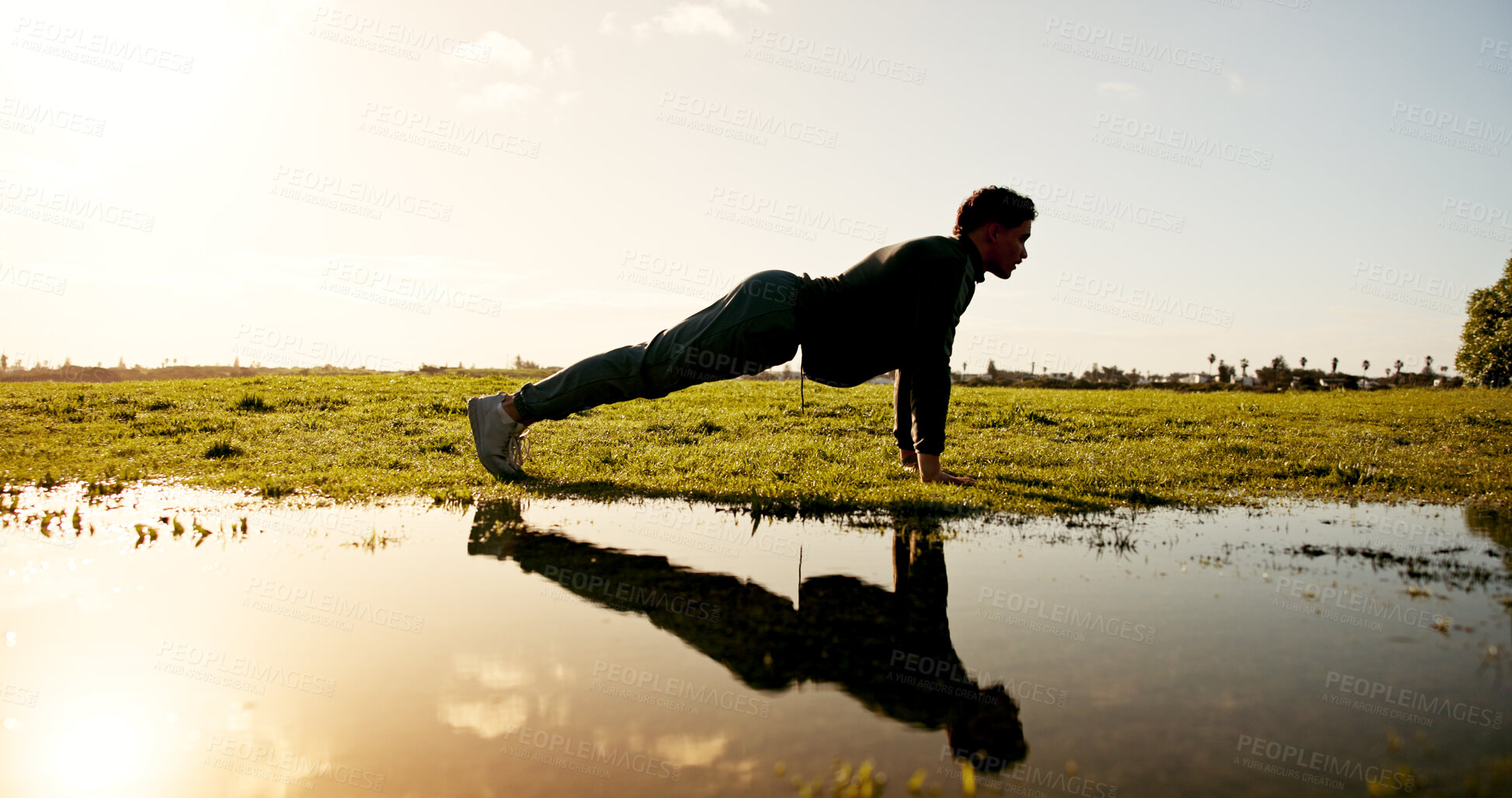 Buy stock photo Man, fitness and nature with push ups by lake for workout, arm exercise or physical activity. Active, male person and lifting body weight with reflection by pond for outdoor training or muscle gain