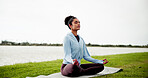 Calm, woman and grass field with mat for meditation, zen or spiritual healing by lake or river. Female person, yoga or wellness with inner peace for tranquility, chakra or mudra on lawn in nature