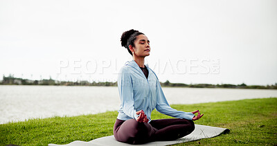 Buy stock photo Calm, woman and grass field with mat for meditation, zen or spiritual healing by lake or river. Female person, yoga or wellness with inner peace in lotus pose for chakra or mudra on lawn in nature