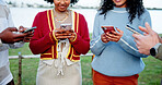 Hands, phone and social media with friends outdoor in circle for connection, networking or sharing. App, text message and typing with student people at lake in nature for communication or online chat