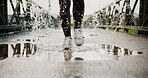Exercise, puddle and shoes running with splash on bridge for endurance, winter workout or sports. Fitness, legs and person with cardio outdoor for race performance, marathon competition and challenge