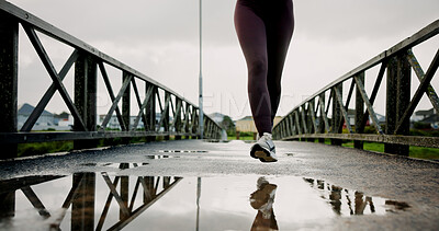Buy stock photo Legs, running and woman with exercise on bridge for pace training, winter workout or dedication. Fitness, puddle and person with cardio outdoor for race endurance, marathon competition and resilience