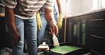 DIY, hand and paintbrush with person in kitchen of apartment for home improvement or renovation. Maintenance, painting and restoration with homeowner couple in new house for real estate investment