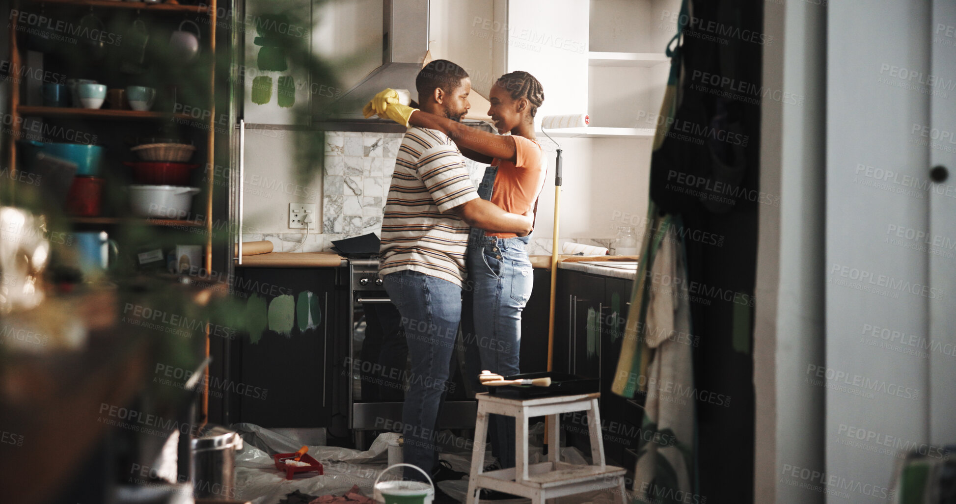 Buy stock photo Renovation, dance and happy couple in home for love, remodeling and bonding together with care. Embrace, man and African woman in kitchen with music to celebrate house upgrade, painting and romance