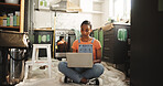Painting, laptop and woman in home for renovation, interior design or online shopping for supplies. Computer, remodeling kitchen and African person on floor for house improvement with creative ideas