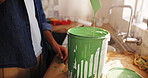 DIY, paint can and renovation with person in kitchen of apartment for development or maintenance. Drip, painting and remodeling with homeowner at counter in house for improvement or interior design