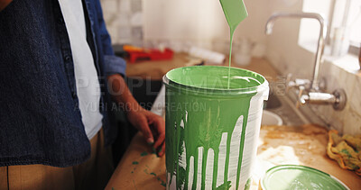 Buy stock photo DIY, paint can and renovation with person in kitchen of apartment for development or maintenance. Drip, painting and remodeling with homeowner at counter in house for improvement or interior design