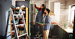 Couple, help and painting kitchen at new house for renovation, interior design and decoration. People, support and furniture with paint brush for diy improvement, remodeling and repairs maintenance