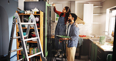 Buy stock photo Couple, help and painting kitchen at new house for renovation, interior design and decoration. People, support and furniture with paint brush for DIY improvement, remodeling and repairs maintenance