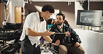 Man, director and producer with tablet for scene, playback or discussion in production studio. Male people, filmaker and assistant talking with technology for cinematography, recording or filming