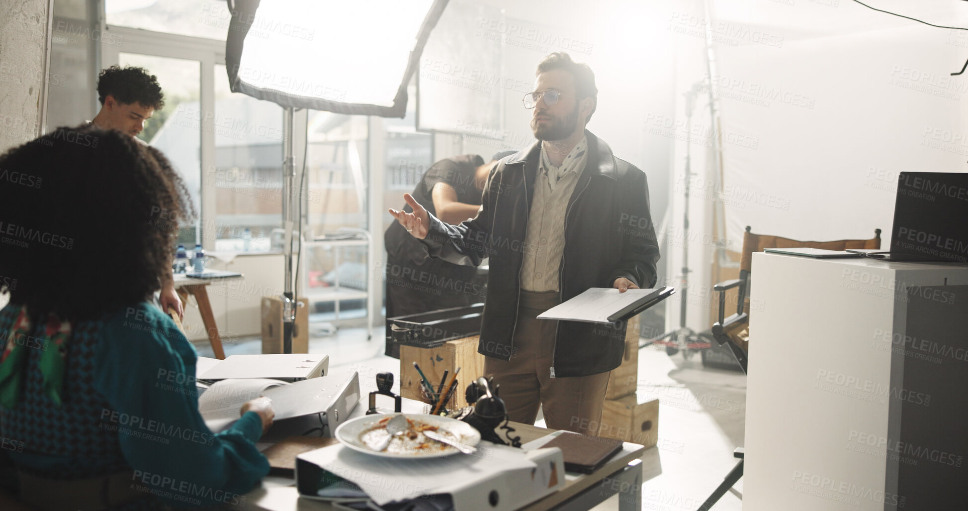 Buy stock photo Actress, conversation and director with script in studio for feedback or instructions on film process. Discussion, production or videography with producer and talent on set for shoot direction