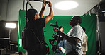 Help, equipment and men with camera on set for adjustment, stabilizing tech and filming. Behind the scenes, videography and person with operator for shooting, production and filmmaking in studio