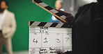 Person, hands and production studio with clapperboard for action, take or behind the scenes in set. Closeup, director or producer with movie slate, green screen or reel for film cut, number or roll
