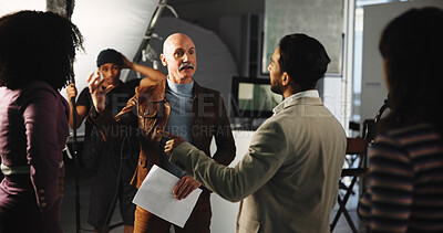 Buy stock photo Talking, actor and director on set for production, filming and shooting with direction for script. Behind the scenes, filmmaking and man with acting cast in discussion, meeting and planning in studio