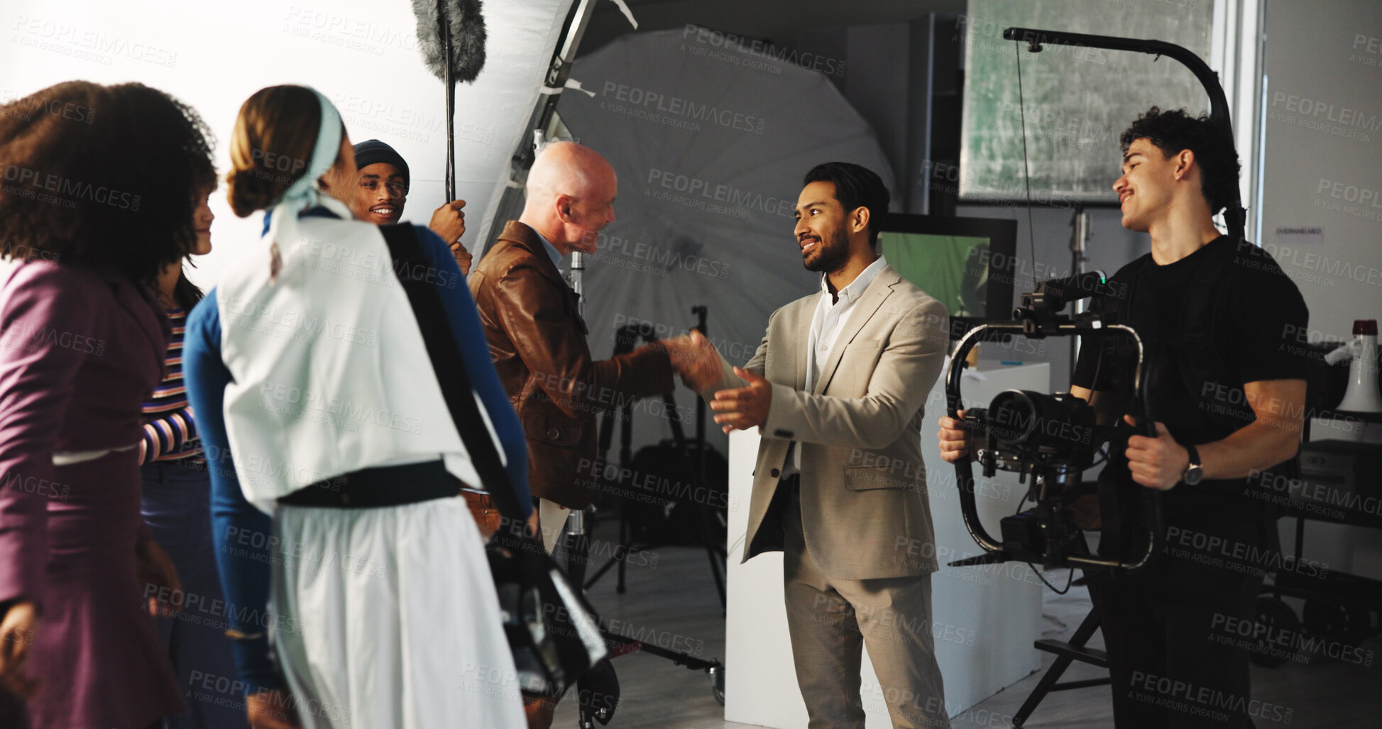 Buy stock photo Handshake, teamwork and director in studio for creative production, filmmaking and shooting success. Behind the scenes, tech and cast with crew celebrate for videography, process and thank you on set