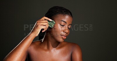 Buy stock photo Gua sha, skincare and black woman in studio for beauty, smooth skin and facial massage. Dermatology, space and person with tools for glow, face treatment and lymphatic drainage on dark background