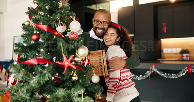 Buy stock photo Decoration, Christmas tree and couple hug in home for bonding, tradition and holiday. December, love and African man embrace woman and hanging ornaments for celebration, festive season and xmas