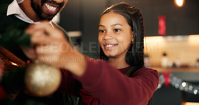 Buy stock photo Smile, child and father decorate Christmas tree for holiday celebration together in home. Girl, dad and bauble for xmas, festive ornament and African family with parent to prepare in house at night