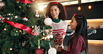 Mother, child and christmas tree decoration in home for festive tradition, holiday or bonding. Help, happy people and hang bauble ornaments in lounge for xmas aesthetic, creativity and celebration