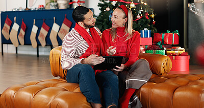 Buy stock photo Christmas, home and couple with tablet, love and search for gifts, festive and bonding together. People, apartment and man with woman, tech and online entertainment with holiday season, talk and Xmas