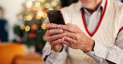 Buy stock photo Hands, person and phone for Christmas at house with social media, browsing internet or gift search. Senior man, bokeh and typing on app for xmas message, online shopping and update of festive season