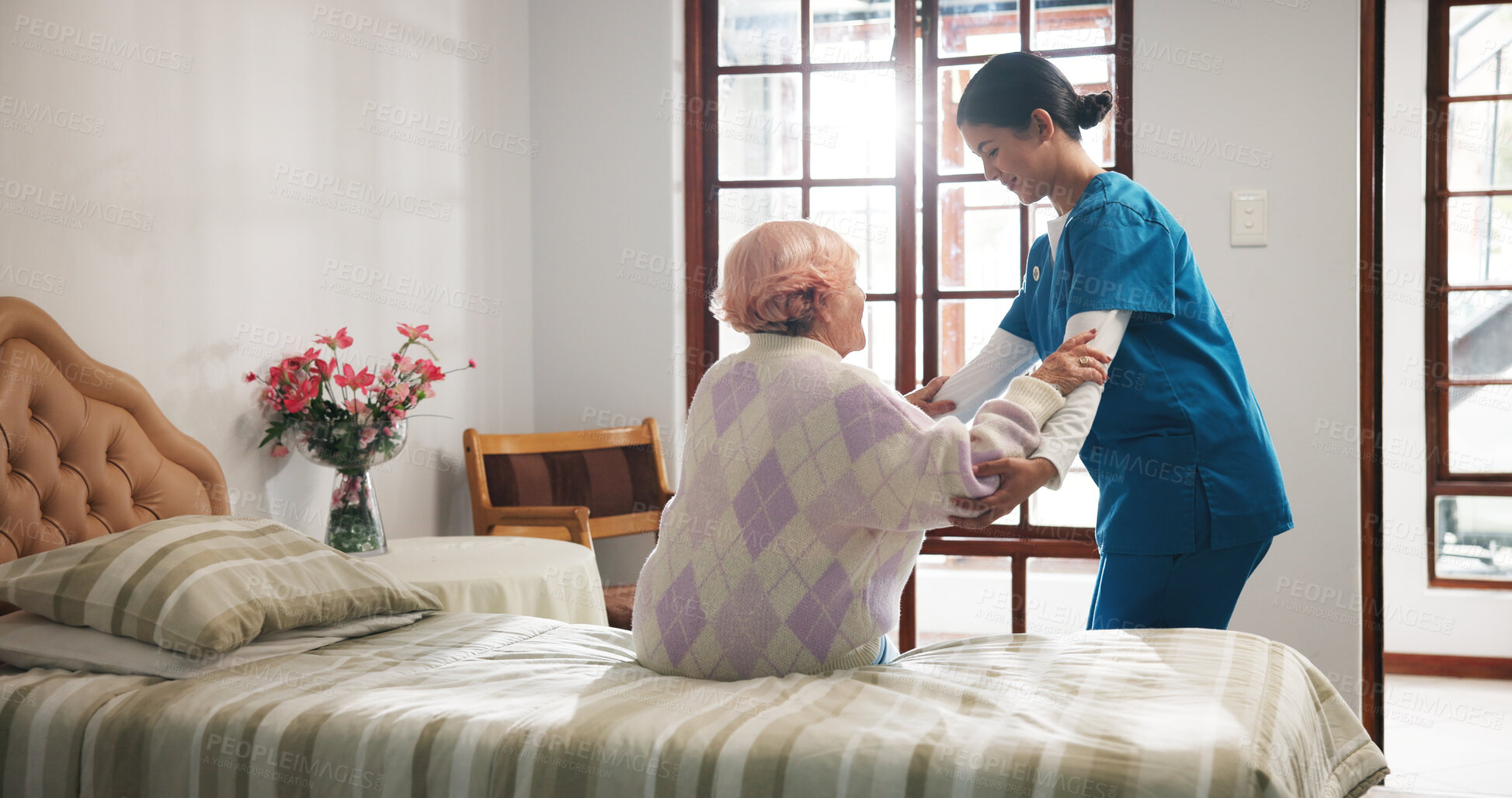 Buy stock photo Senior woman, caregiver and help on bed with care, assisted living and support in nursing home. Elderly patient, nurse and mobility aid in bedroom for friendly service, healthcare and consulting