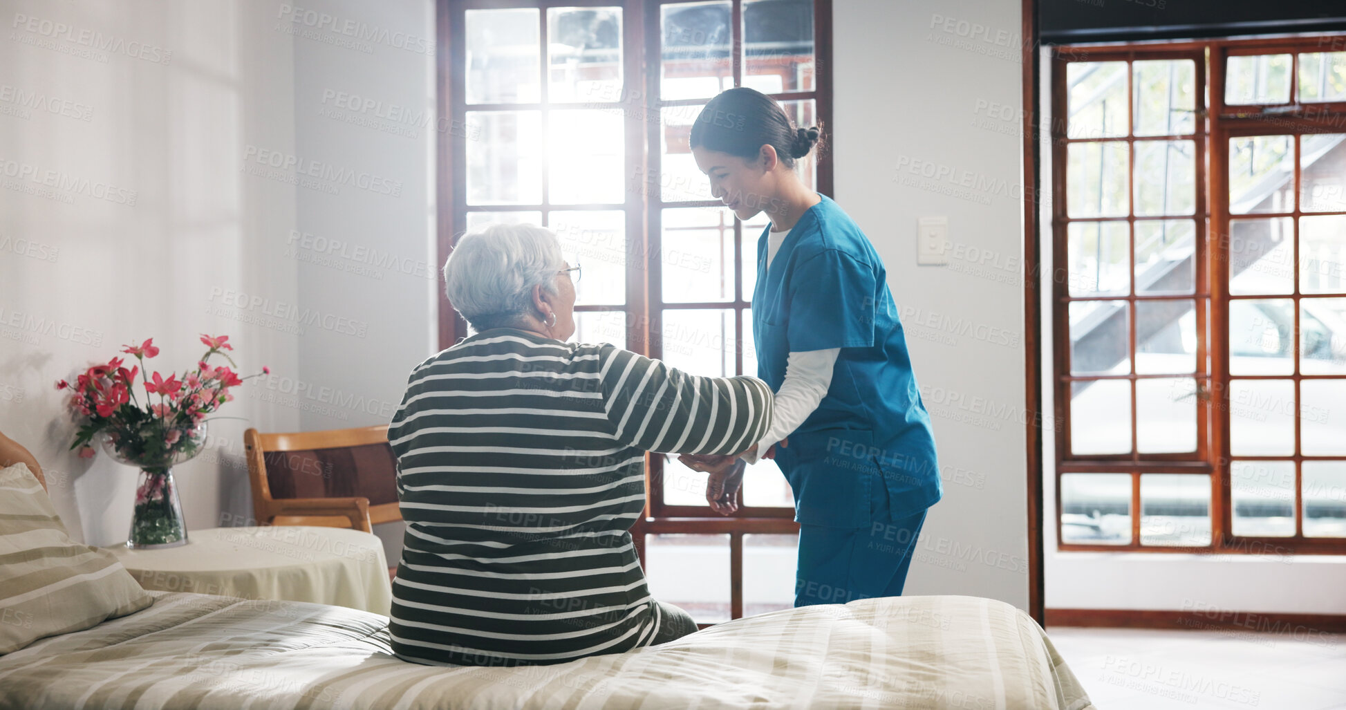 Buy stock photo Elderly woman, caregiver and help on bed with care, assisted living and support in nursing home. Senior patient, nurse and mobility aid in bedroom for friendly service, healthcare and consulting