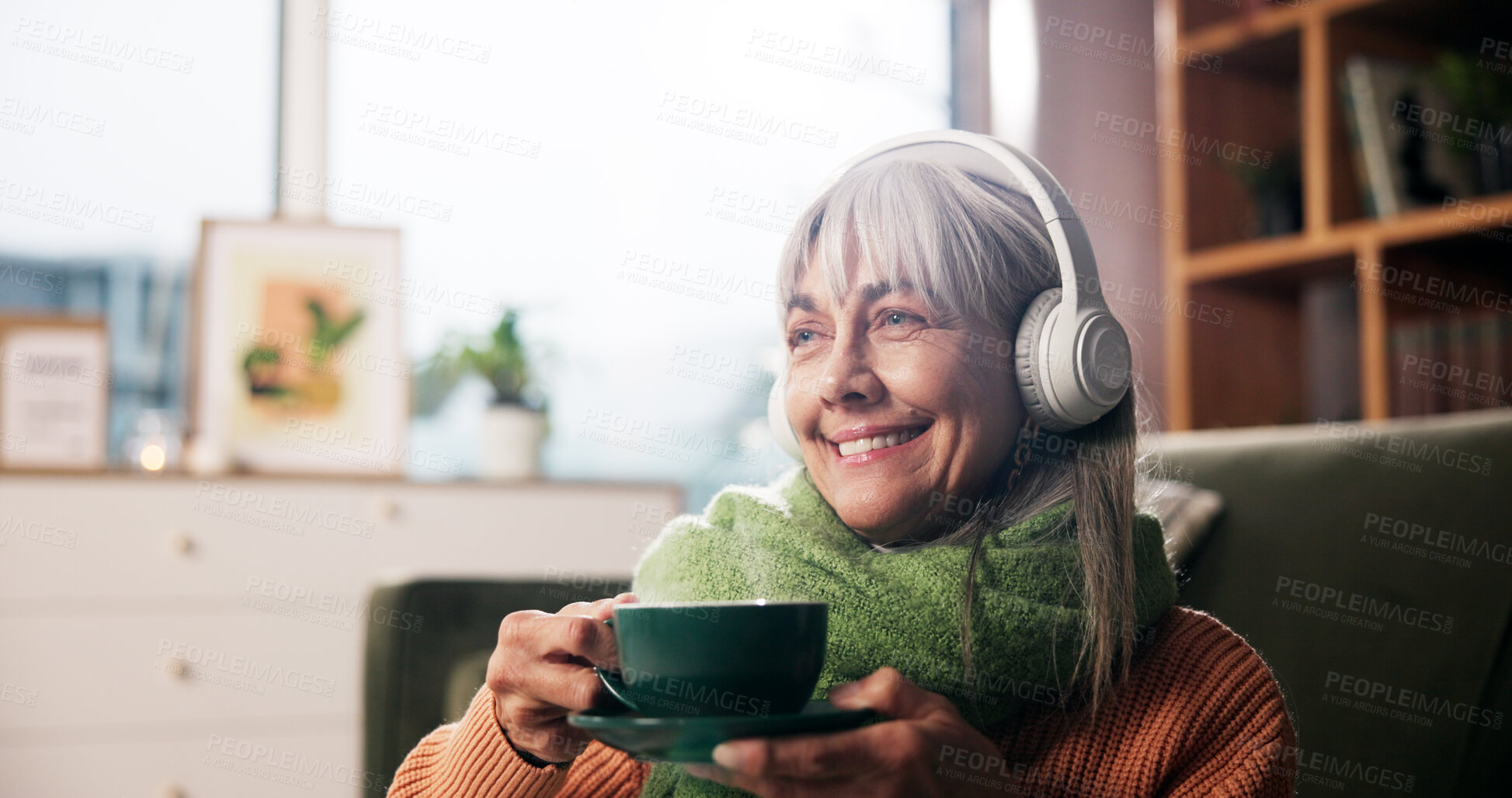 Buy stock photo Senior woman, coffee and headphones on sofa with smile, thinking and listen to music in retirement home. Person, relax and happy with drink, beverage or tea cup with audio streaming on couch in house