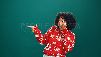 Buy stock photo Christmas, pointing and whisper with woman in studio for holiday season, celebration and promotion. Festive deals, xmas event and announcement with person on green background space with mockup