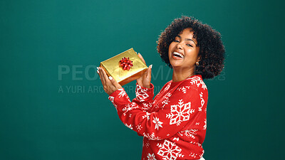 Buy stock photo Gift box, portrait and black woman in studio for Christmas with tradition, prize or giveaway. Excited, mockup space and African female person with xmas present for festive season by green background.
