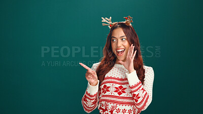 Buy stock photo Christmas, woman and pointing in studio for announcement, advertising and mockup space. Marketing, offer and person show promotion, xmas discount and holiday sale coming soon on green background