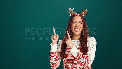 Buy stock photo Christmas, pointing and smile with portrait of woman in studio for holiday season, celebration and promotion. Festive deals, xmas and announcement with person on green background space for mockup