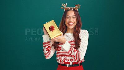 Buy stock photo Christmas gift, portrait and woman in studio for tradition, prize or giveaway on holiday. Excited, mockup space and female person from Mexico with xmas present for festive season by green background.