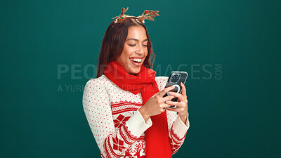 Buy stock photo Christmas, online shopping and woman with smartphone, studio and planning for festive season on web. Green background, mockup space and person with xmas sweater, mobile or scroll for holiday discount