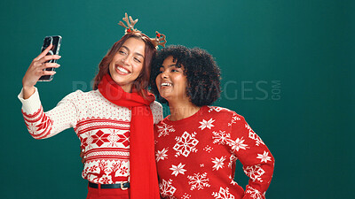 Buy stock photo Christmas, friends or women with selfie in studio for holiday memory, festive fashion or bonding. Space, people or happy with photography on green background for xmas party or profile picture update