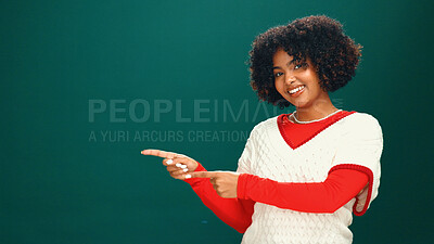 Buy stock photo Christmas, woman and pointing to space in studio for advertising, marketing or mockup. Portrait, smile and African person with promotion offer, xmas discount and festive sale on green background