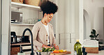 Cooking, woman and cutting vegetables in kitchen, smile or culinary skills for dinner, food and home. Happy, African person and ingredients for salad in house, nutrition and meal prep for gourmet
