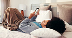 Reading, relax and woman with phone on bed for social media, networking and online chat in home Happy, bedroom and African person on smartphone for internet, website and typing message on mobile app