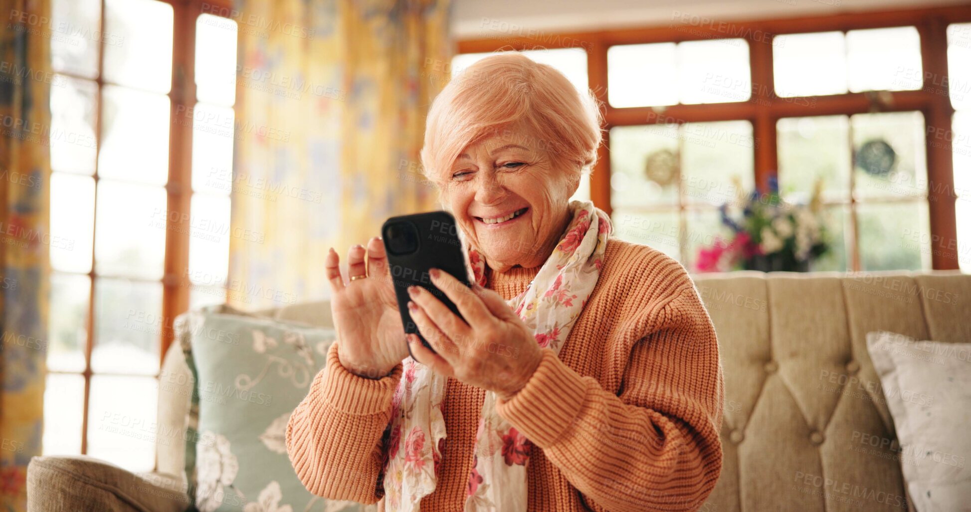 Buy stock photo Senior woman, happy and phone in home for online bingo, playing word search or reading news. Retirement, relax and old person with smartphone on sofa for streaming service, internet games or browsing