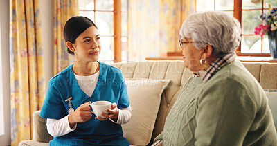 Buy stock photo Caregiver, elderly woman and tea on sofa with discussion, support feedback and relax in retirement home. Assisted living, senior patient and nurse in lounge with drink, bonding and daily checkup