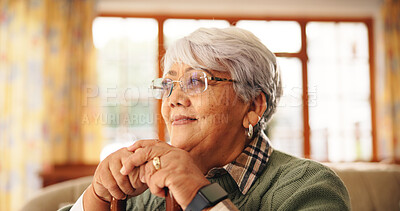 Buy stock photo Walking stick, relax and senior woman in home with nostalgia, retirement or remember memory. Thinking, wood cane and elderly female person with a disability on sofa with daydreaming in house.
