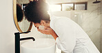 Woman, water and wash face for skincare in bathroom, acne control and cleansing routine at mirror. African person, dermatology and soap in home for facial treatment, skin hydration and exfoliation