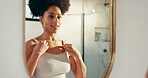 Woman, mirror and check for beauty in bathroom with results, reflection and grooming routine in morning. Good mood, facial glow or person in home with smile, hygiene and skincare in apartment