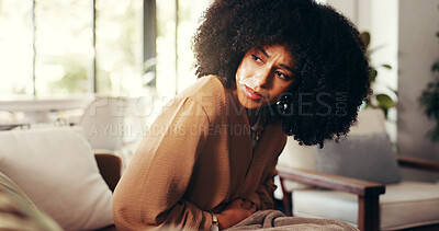Buy stock photo Girl, stomach and cramps or pain on sofa for menstruation, ovarian cysts and discomfort in lounge. Woman, home and abdominal ache for monthly cycle, period and tension or strain in house living room