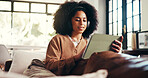 Headphones, woman or scroll with tablet on sofa for music search, streaming podcast or online show. Cozy, african person or relax with digital app in home with sound playlist, movie and weekend break