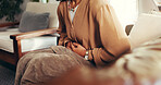 Woman, hands and cramps or pain on sofa for menstruation, ovarian cysts and discomfort in lounge. Girl, home and abdominal ache for monthly cycle, period and tension or strain in house living room