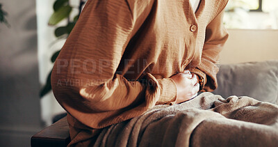 Buy stock photo Girl, hands and cramps or pain on sofa for menstruation, ovarian cysts and discomfort in lounge. Woman, home and abdominal ache for monthly cycle, period and tension or strain in house living room