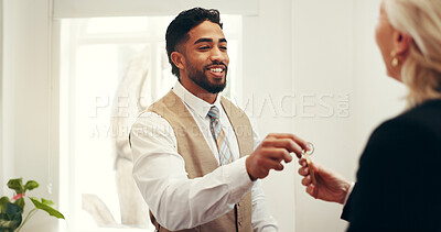 Buy stock photo Happy man, keys and hotel lobby for businesswoman, welcome or registration for accommodation. People, check in and concierge service with client, help desk and hospitality for suite booking at lodge